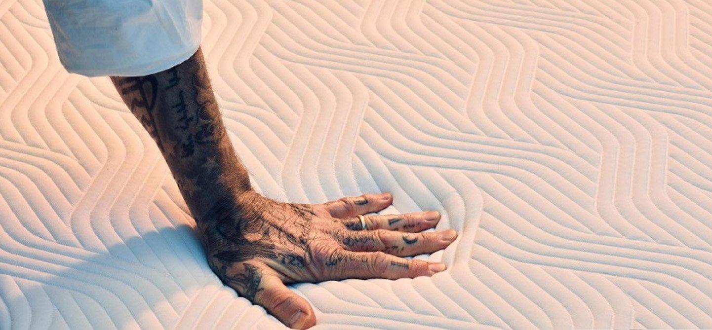 David Beckham's hand pressing a Tempur Mattress
