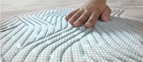 La main apparaît sur le matelas Tempur Form Adapt Material