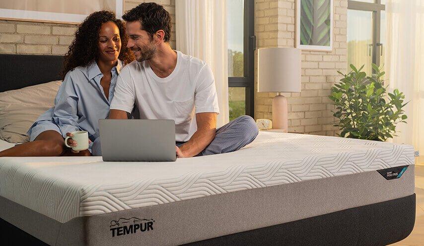 Szczęśliwa para w łóżku z laptopem